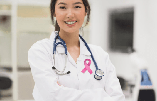 female scientist wearing a breast cancer awareness pink ribbon