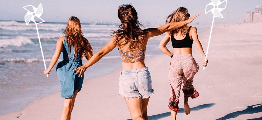 lastminute summer holidays banner showing 3 women dancing down a beach