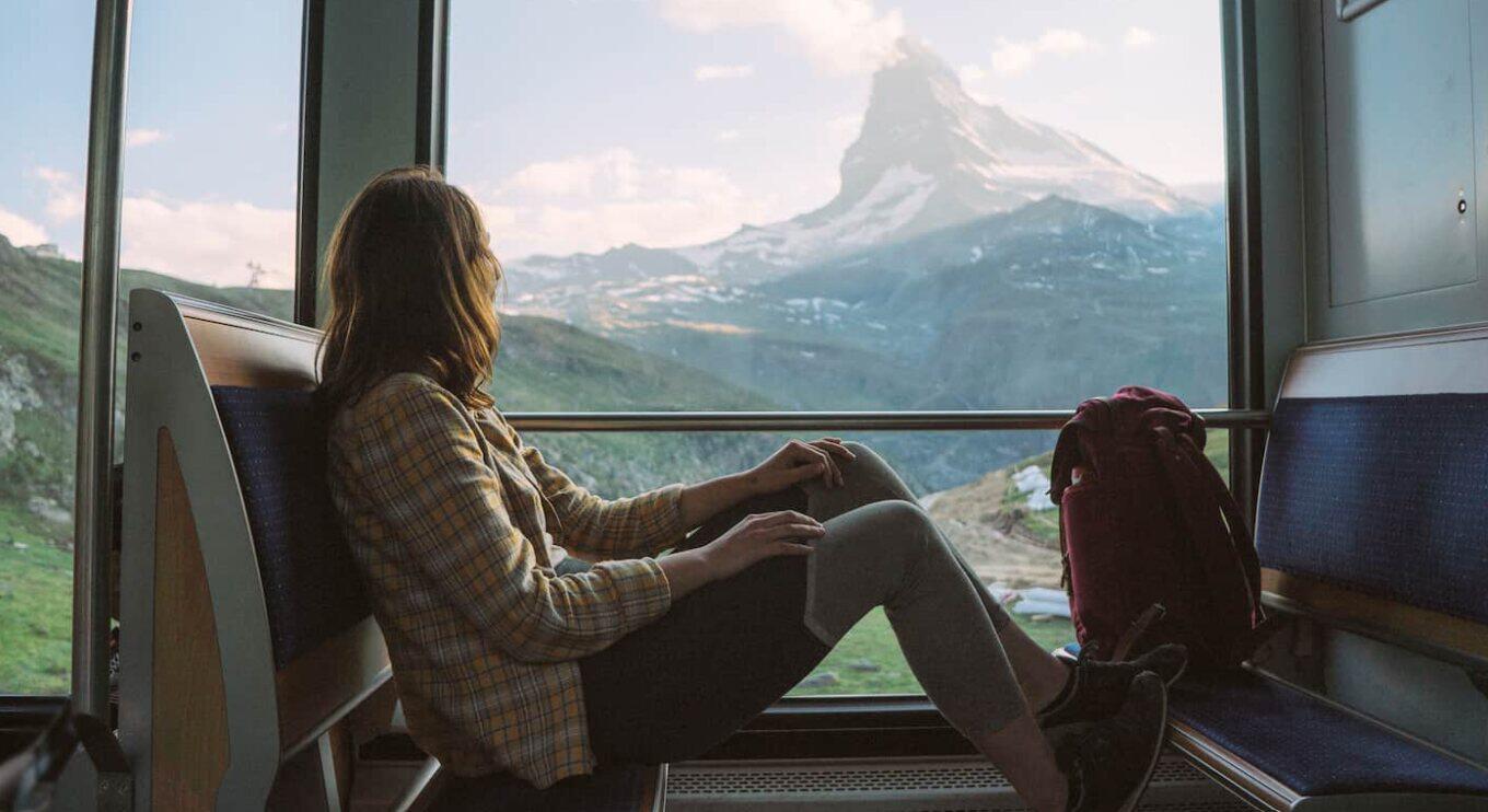 trainline tickets banner showing a woman on a train looking out of the window at a mountain view